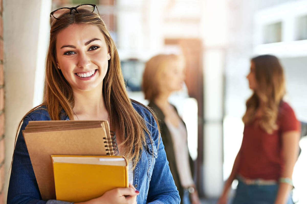 A teacher with course materials outside an Italian campus