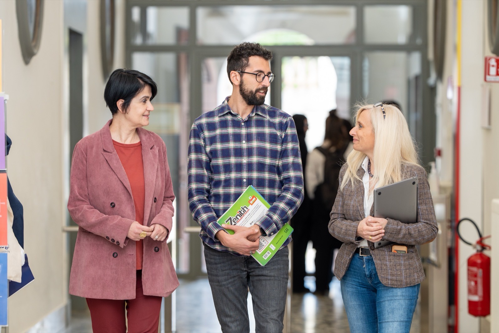 Three teachers talking in a corridor of the Unicollege campus